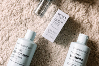 Silvina London GREY hair care products including shampoo, conditioner, and a bottle on a textured surface.